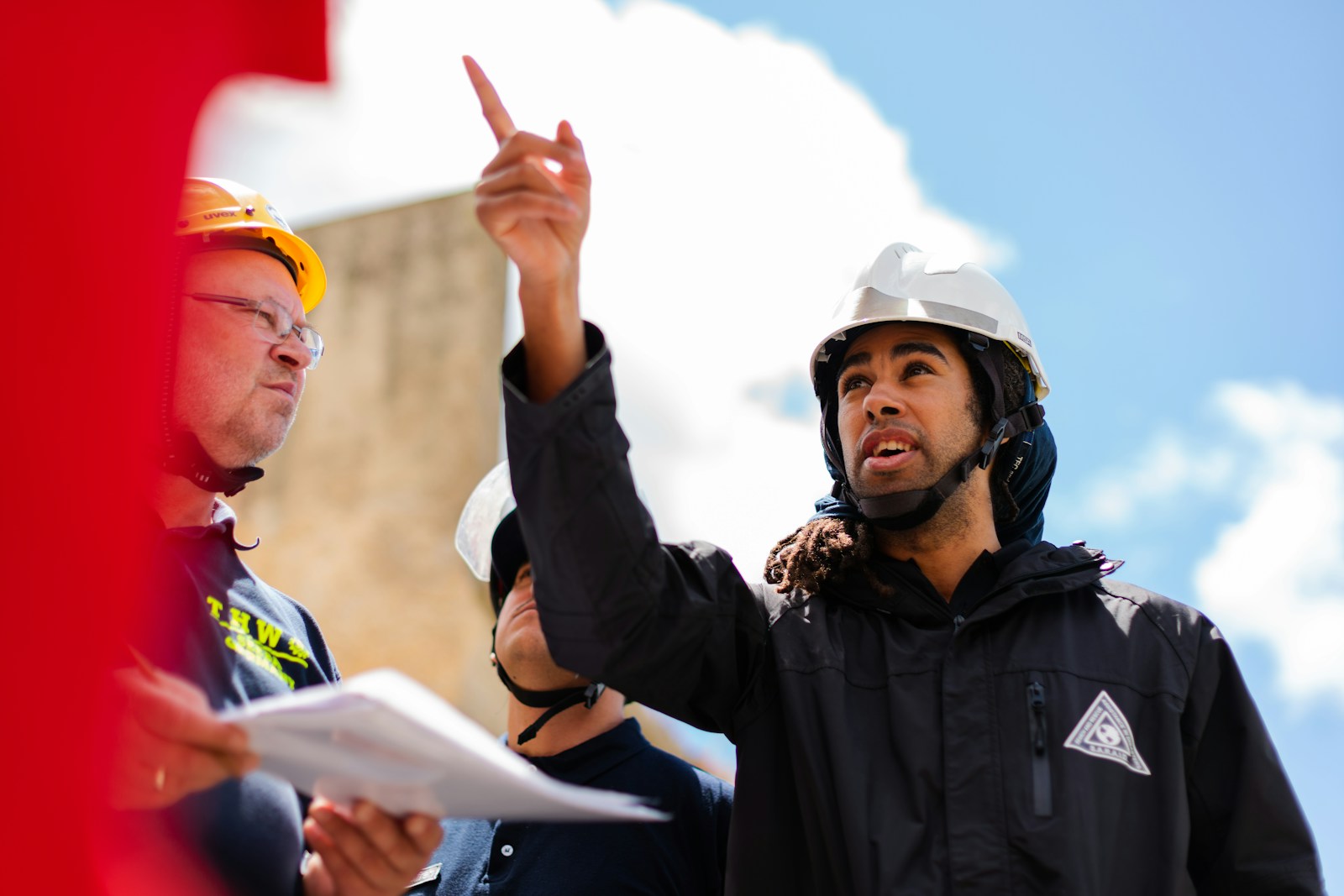 man in black jacket wearing yellow hard hat, contractors